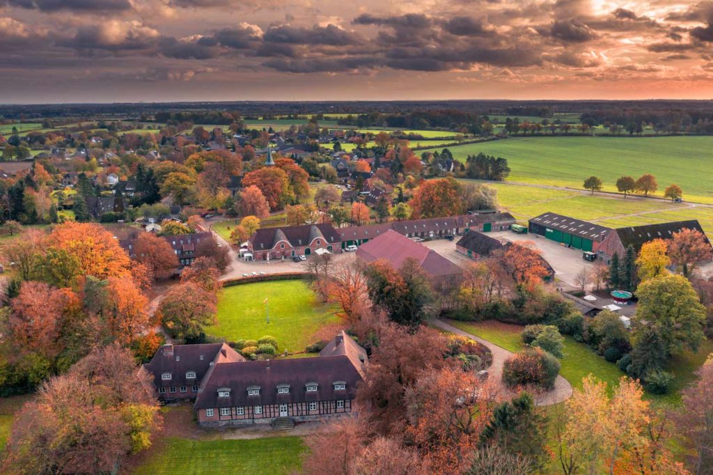 Die Jagdschule auf dem Gut Basthorst bei Hamburg im Herbst bei Sonnenuntergang aus Norden in Richtung. Rechts der Sonnenuntergang über Hamburg.